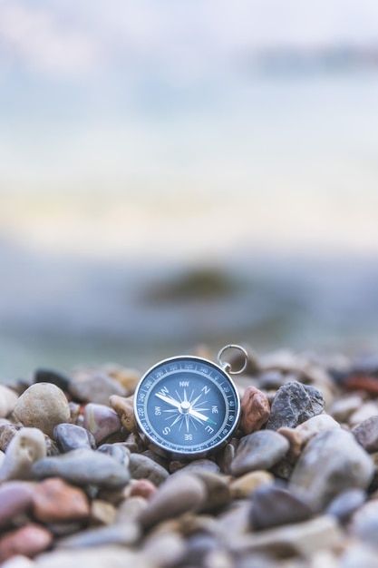 a compass sitting on top of a pile of rocks