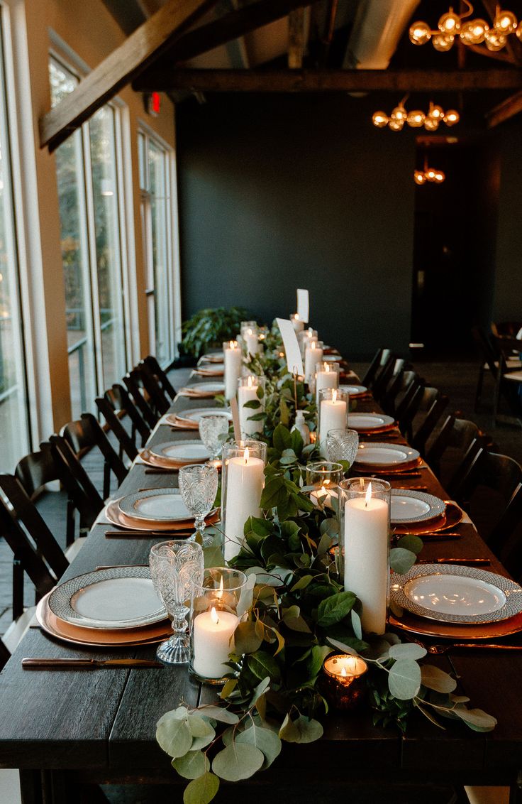 a long table with candles and plates on it