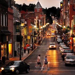 a city street filled with lots of traffic next to tall brick buildings and green trees