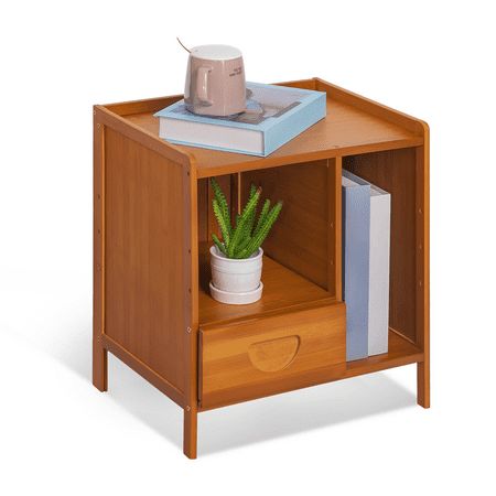 a small wooden table with a potted plant and books on the shelf next to it