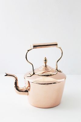 a pink tea pot with a handle on the side and a silver lid is shown in front of a white background