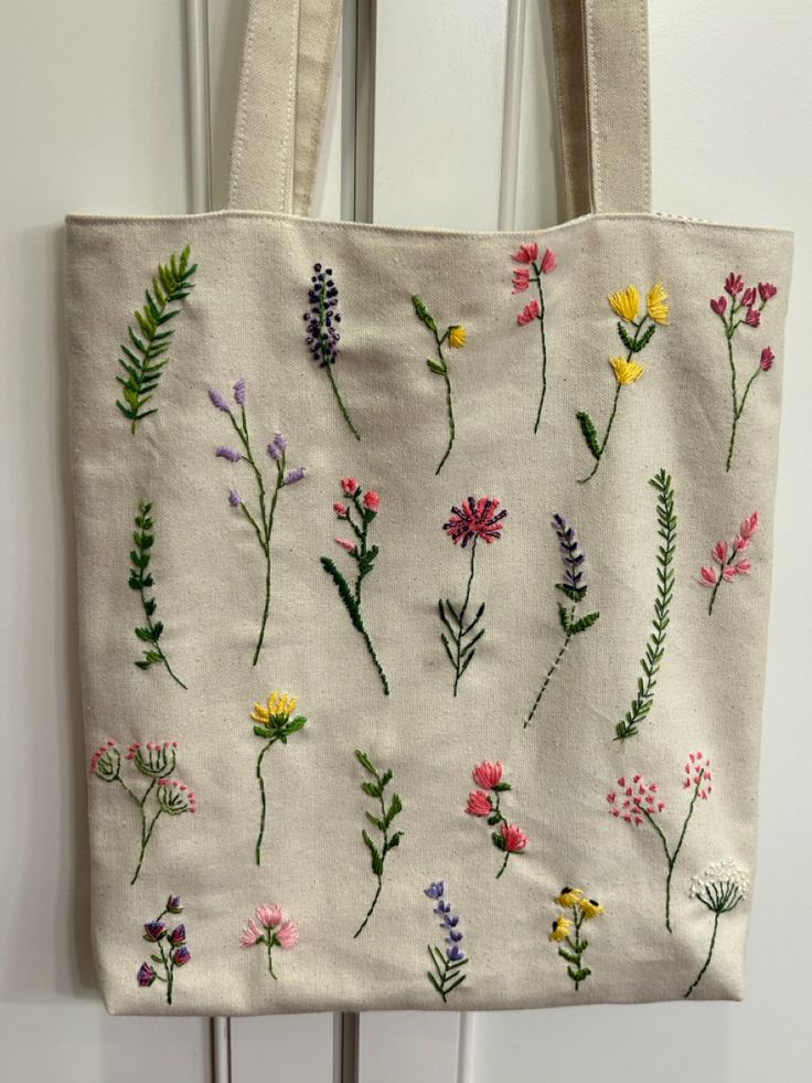 a white bag with embroidered flowers on it