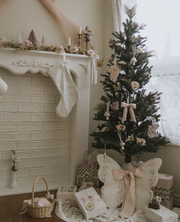 a decorated christmas tree in front of a fireplace with stockings and presents on the floor