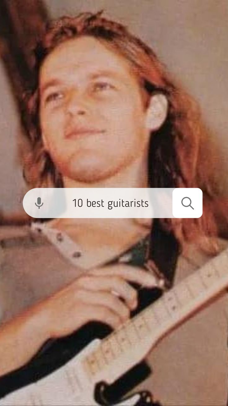 a man with long hair holding a guitar in front of his face and looking up at the camera