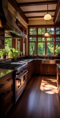 a kitchen with wooden floors and windows overlooking the trees in the distance is lit by sunlight coming through the window panes