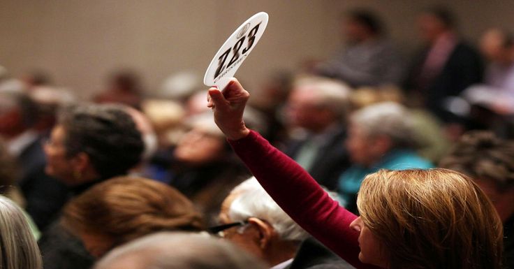 a woman holding up a white frisbee in the middle of a room full of people