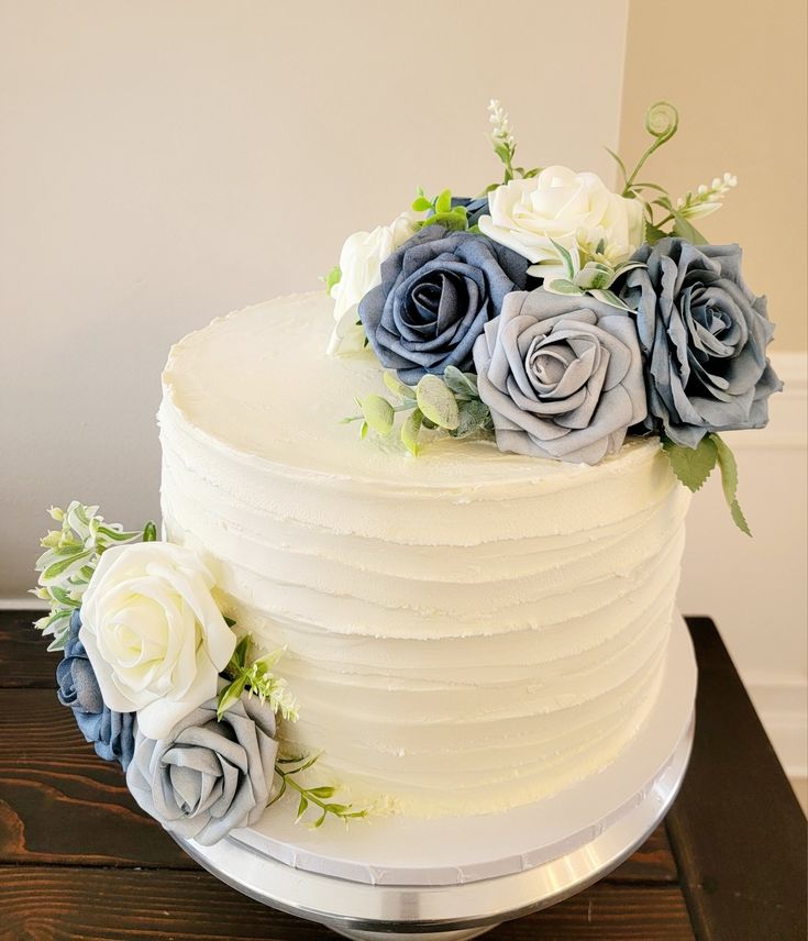 a white cake with blue and grey flowers on top