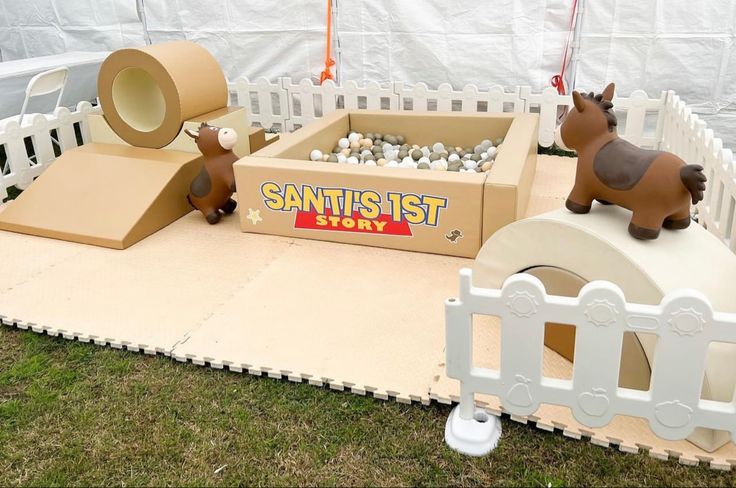 an outdoor play area with fake animals and toys on it's sides, including a cardboard box that says san francisco story