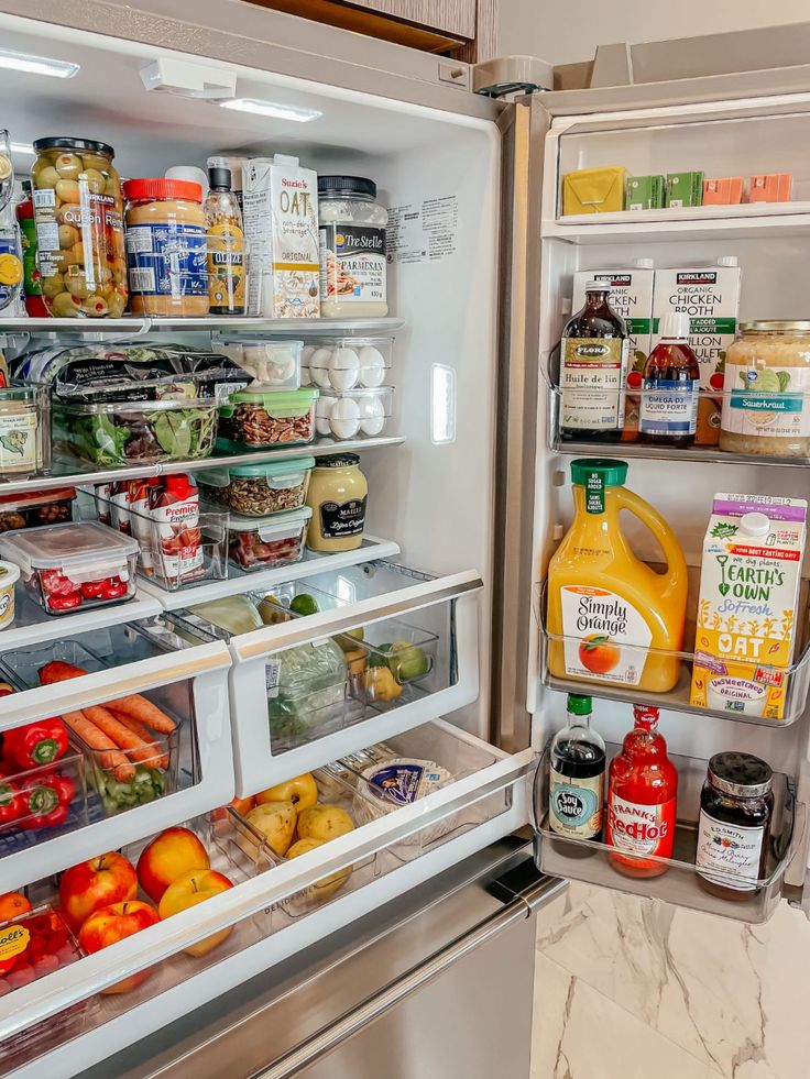 an open refrigerator filled with lots of food and condiments on the shelves,