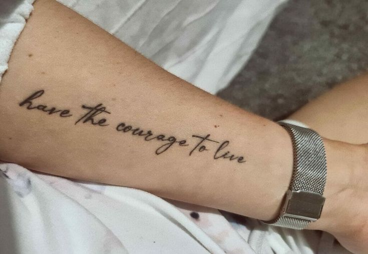 a woman with a tattoo on her arm that says, have the courage to live