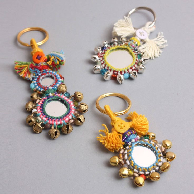 three different types of key chains on a gray surface, one with an animal and the other with flowers