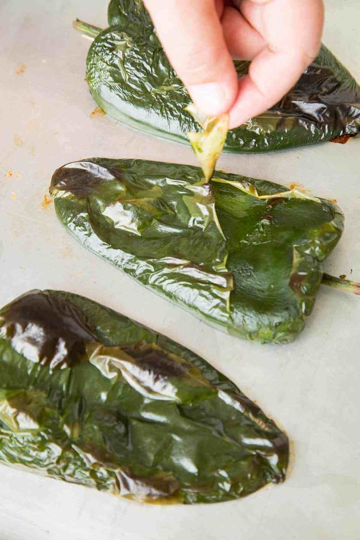 someone is peeling the leaves off of some green peppers