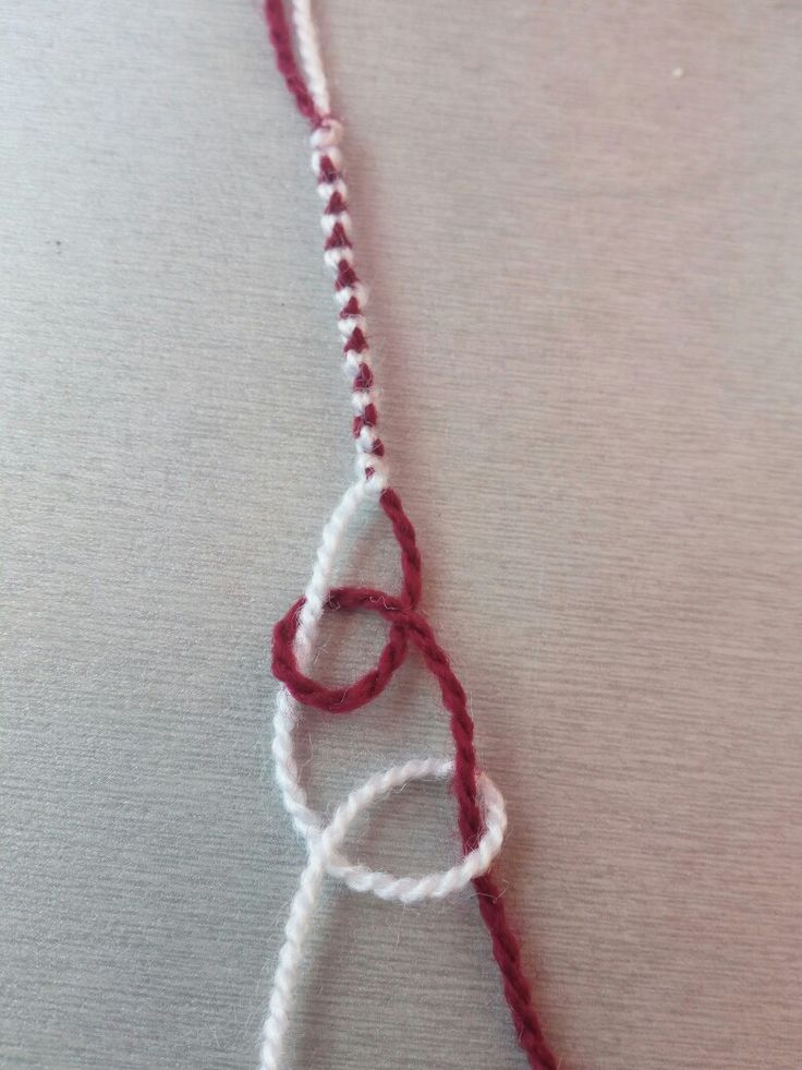 a red and white piece of yarn on top of a table