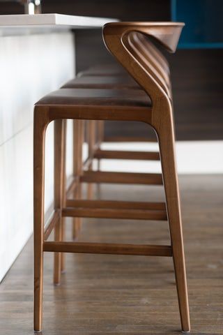 there is a counter with several stools next to it in the kitchen and on the floor