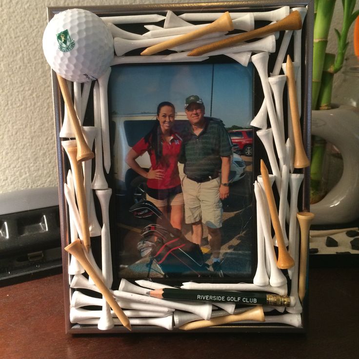 two people standing next to each other in front of a picture frame