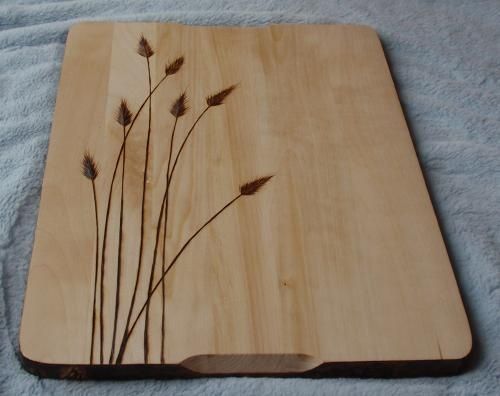 a wooden cutting board with some plants on it