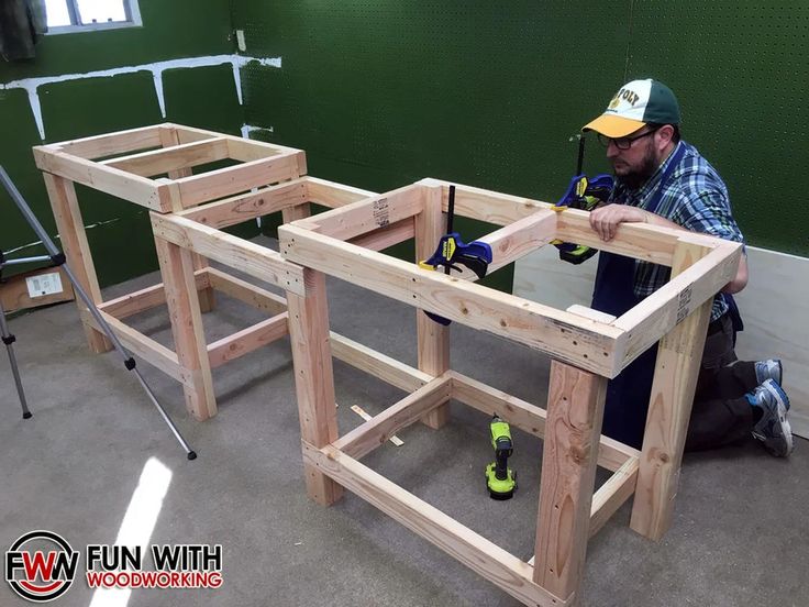 a man working on some wooden furniture in a room with green walls and flooring