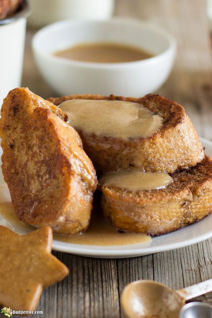 two pieces of french toast on a white plate with caramel sauce in the middle