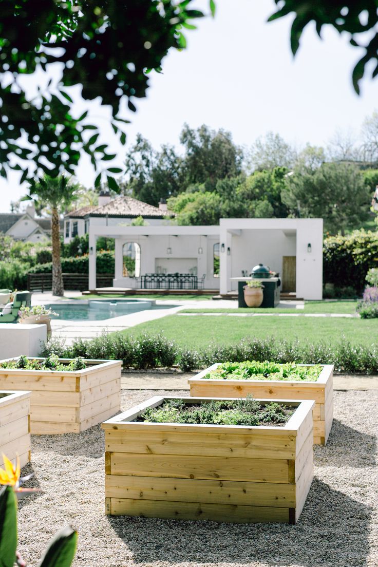 several wooden planters sitting in the middle of a yard