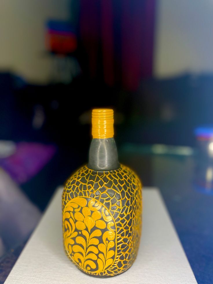 a yellow and black bottle sitting on top of a white tablecloth covered countertop