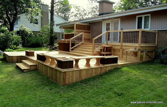 a deck built into the side of a house with stairs and steps leading up to it