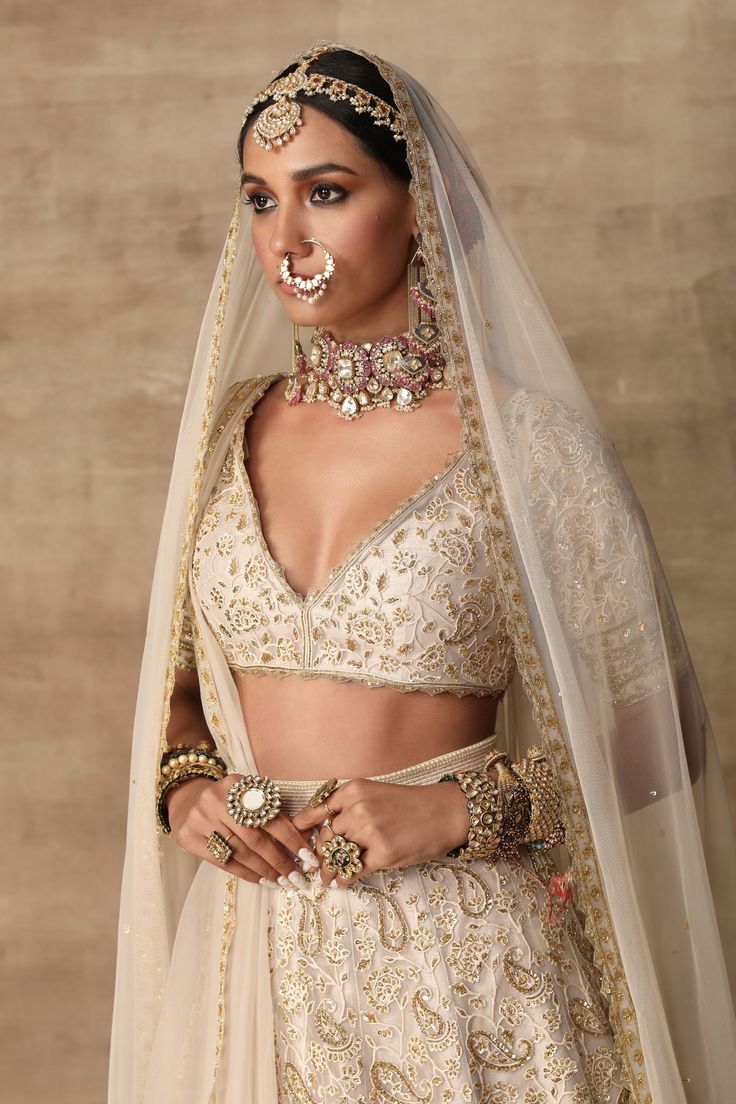 a woman wearing a bridal outfit and jewelry