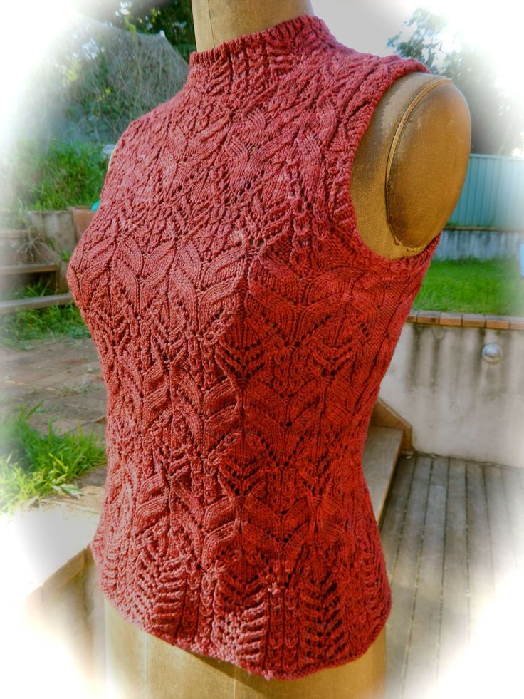 a woman's red sweater on top of a wooden mannequin