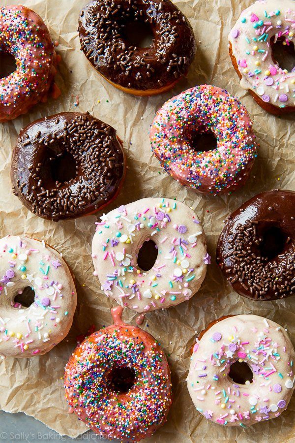 a bunch of doughnuts with sprinkles are on the table and ready to be eaten