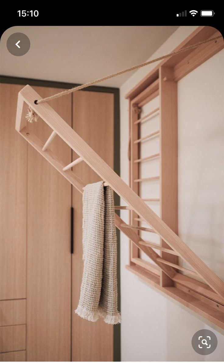 a towel hanging from a clothes rack in a room with wooden closets and cabinets