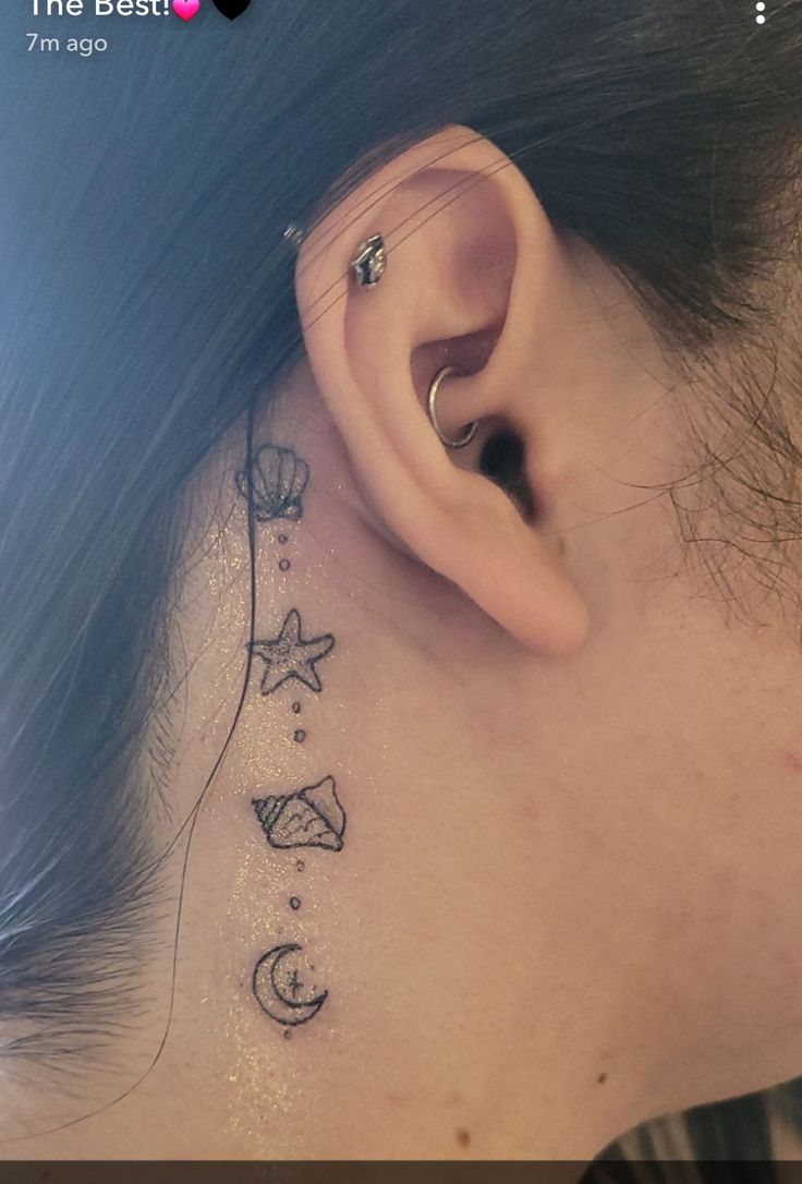 a woman's behind the ear tattoo with stars and moon on her left side