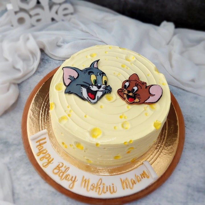 a yellow cake with two cartoon cats on it