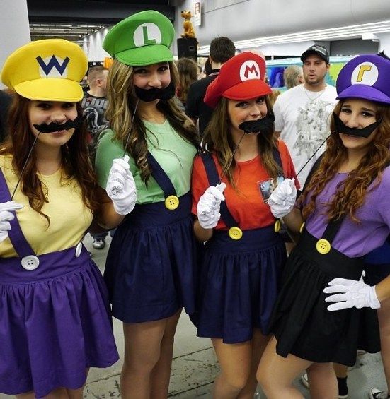 three women dressed up as mario bros and luigi in costume at an event with other people