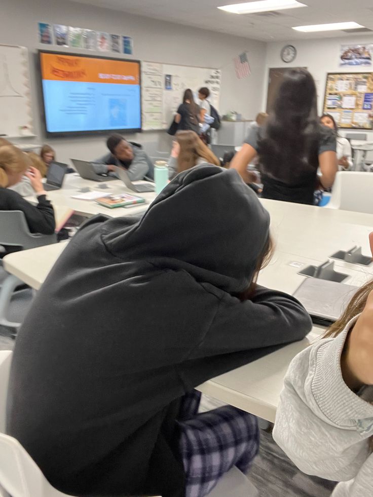 a group of people sitting at desks in a classroom