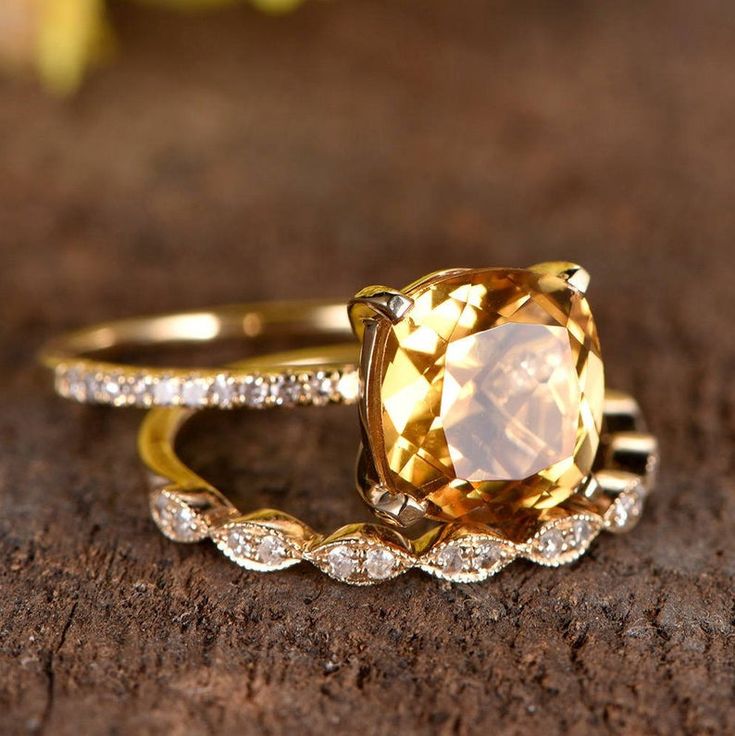 a yellow diamond ring sitting on top of a wooden table