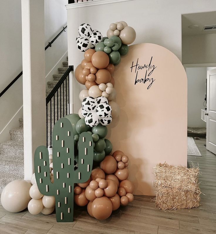 a balloon arch is decorated with balloons and cactus decorations