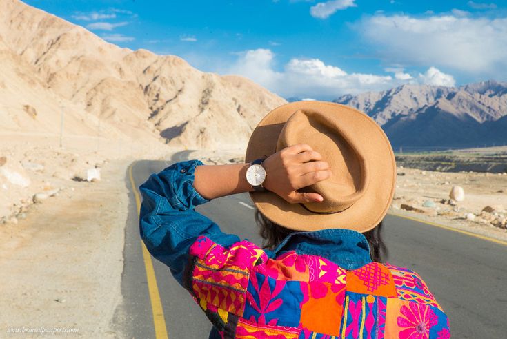 a woman with a hat is standing on the road