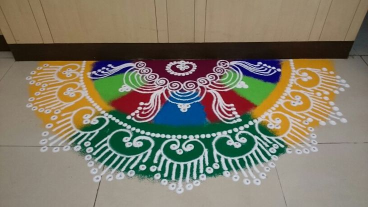 a colorfully decorated floor mat in the middle of a kitchen with white and green designs on it