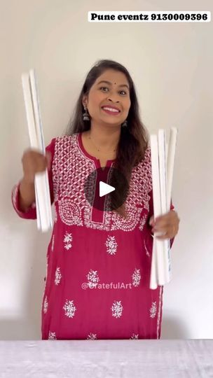 a woman holding two white sticks in her hands