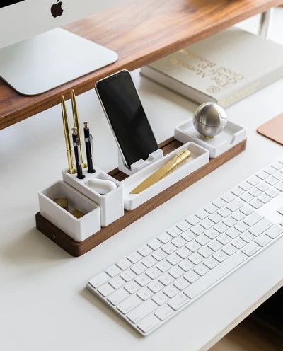 a desk with a keyboard, mouse and cell phone on it