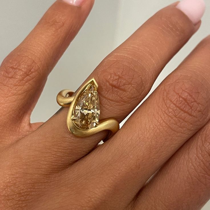 a woman's hand with a yellow diamond ring on top of her left hand