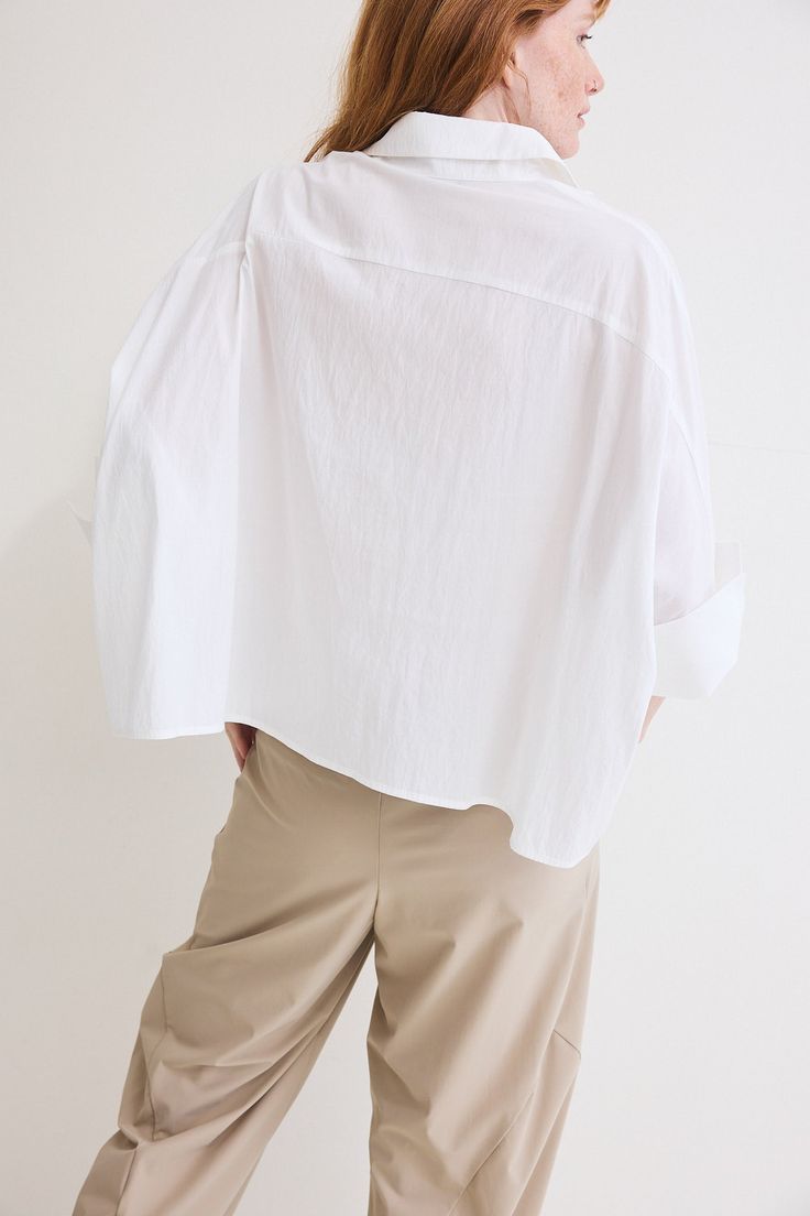 The Poplin Oversized Cropped Blouse is a contemporary twist on a classic wardrobe staple. Crafted from premium poplin fabric, this blouse effortlessly combines comfort, style, and versatility to elevate your everyday look White Oversized Poplin Shirt, Modern Oversized Button-up Tops, Oversized White Poplin Shirt, Modern Oversized White Blouse, Modern Tops With Shirttail Hem For Daywear, Modern Oversized Button-up Blouse, Oversized Classic Poplin Blouse, Classic Oversized Poplin Blouse, White Poplin Shirt For Daywear