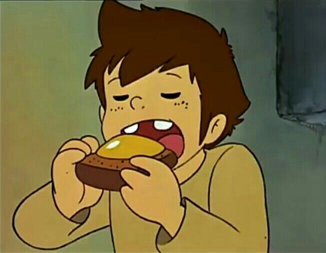 a young man eating a chocolate donut with his mouth wide open and tongue out