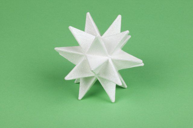 a white origami star on a green background