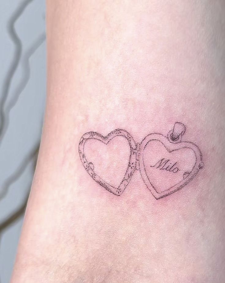 two heart shaped tattoos on the side of a woman's leg, one with an inscription