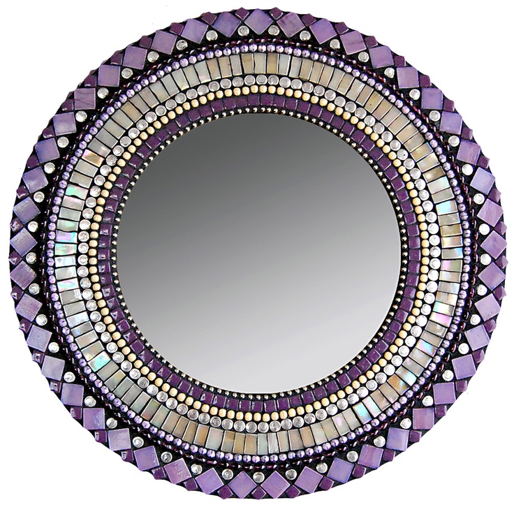 a round mirror with an intricate design on it