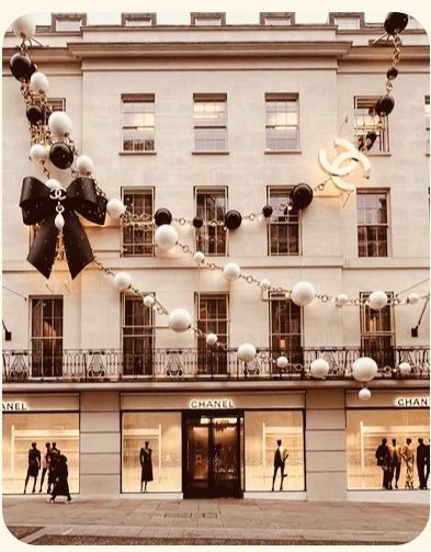 people are walking in front of a building decorated for christmas