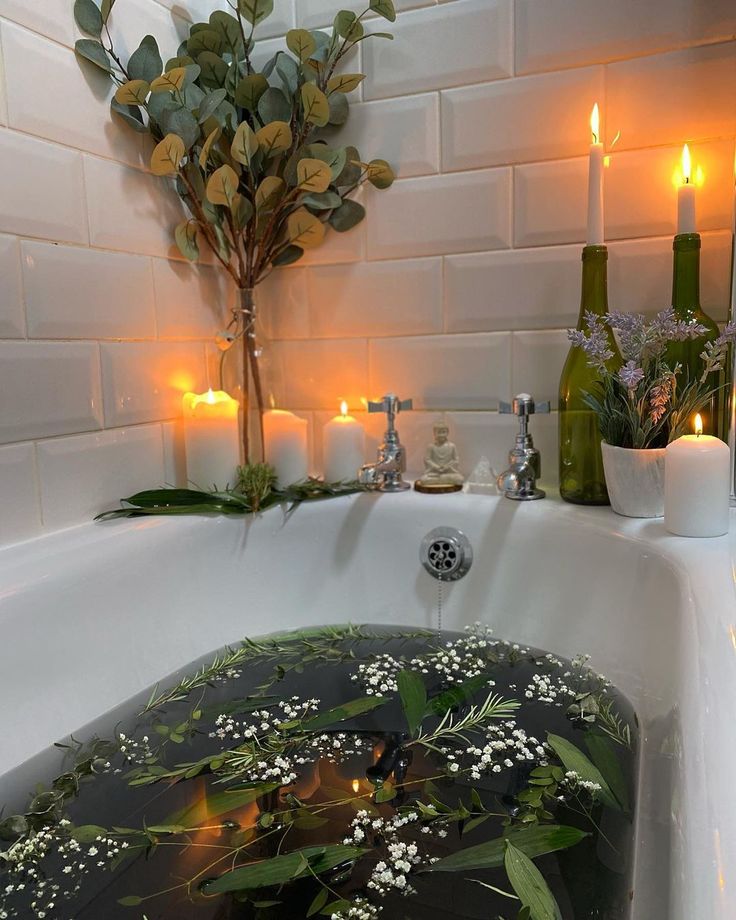 a bathtub with candles and flowers in it