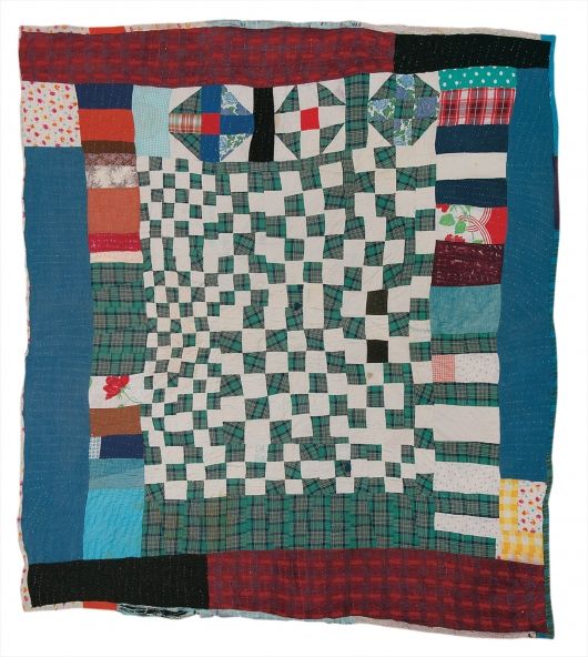 a patchwork quilt is displayed on a white surface