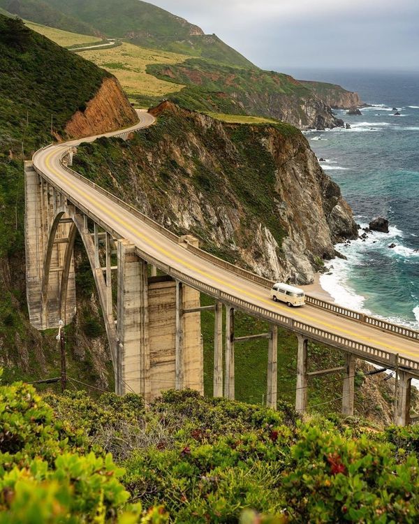 a highway going over the ocean on top of a cliff next to an ocean side