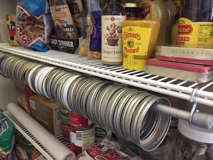 an organized pantry with lots of food and condiments on the shelves, including canned foods